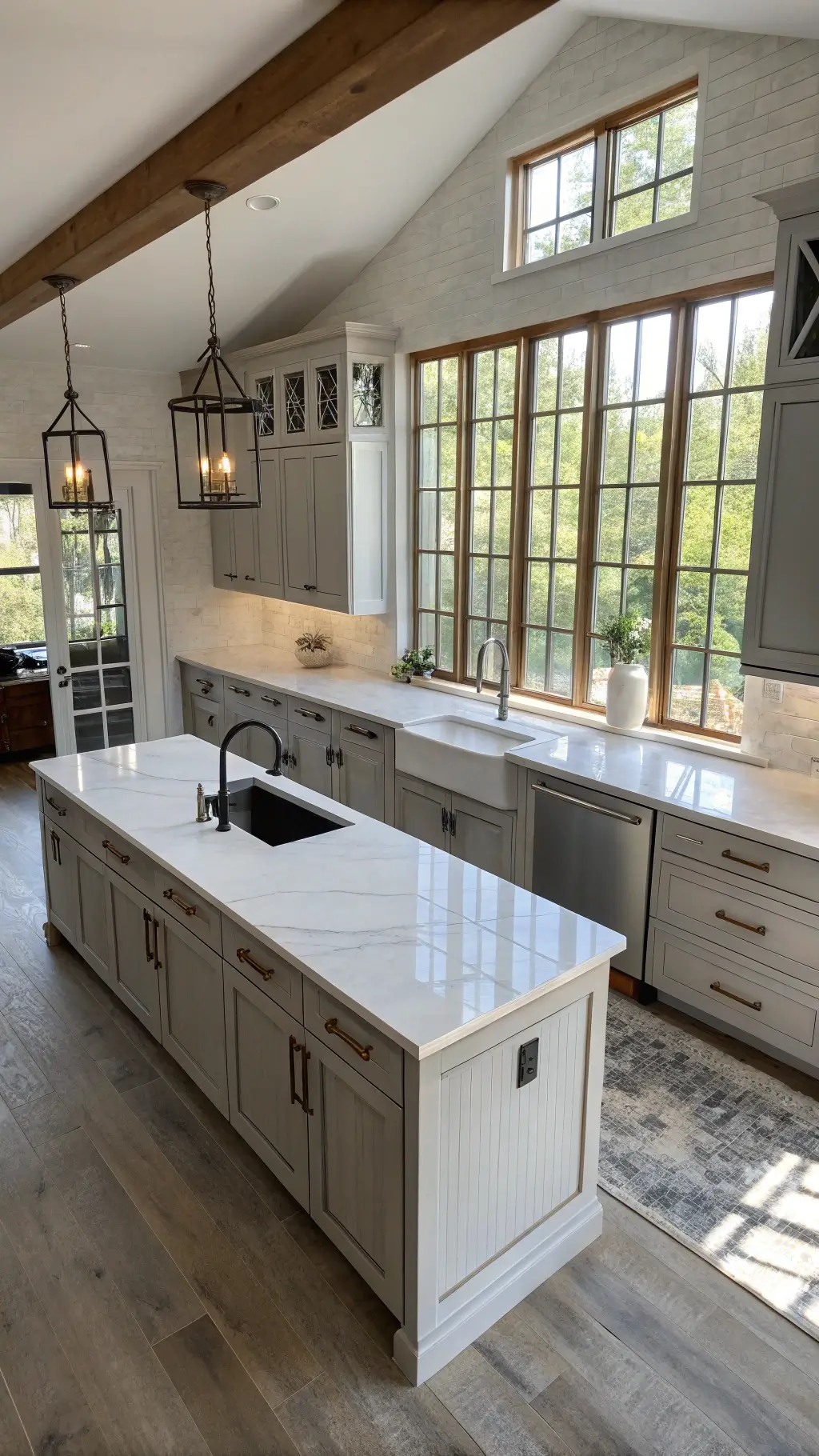 Modern farmhouse kitchen featuring light gray cabinets, waterfall quartz island, steel-framed windows, and white oak accents, shot from above with dramatic side lighting